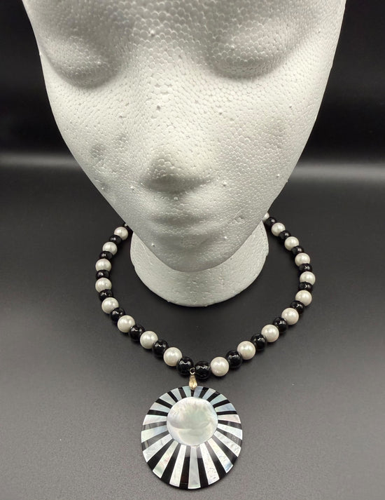 Hand made necklace with black and white beads and a starburst pendant